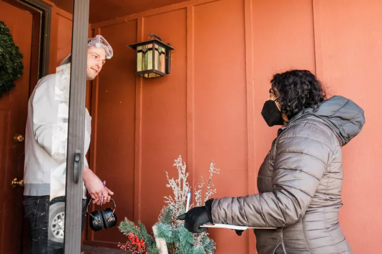 Megan Srinivas speaking with a man on his doorstep