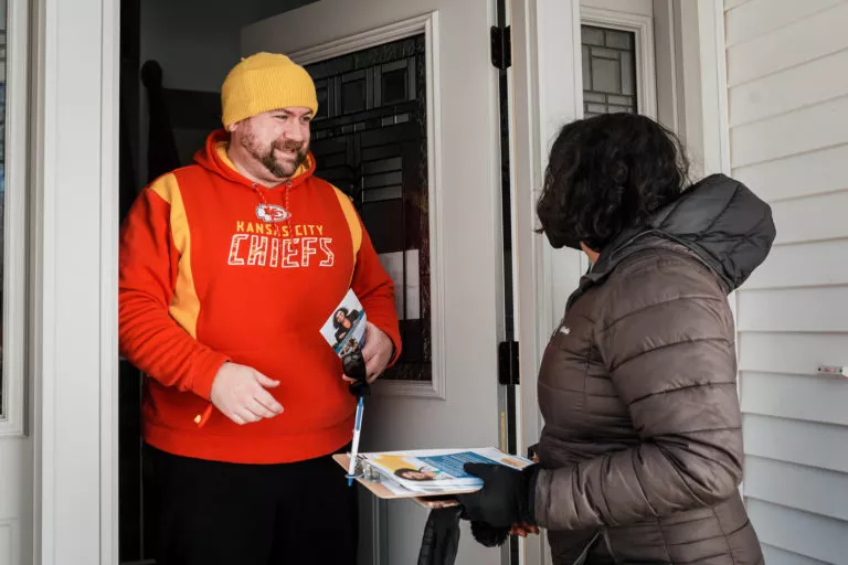 Megan Srinivas speaking with a man on his doorstep