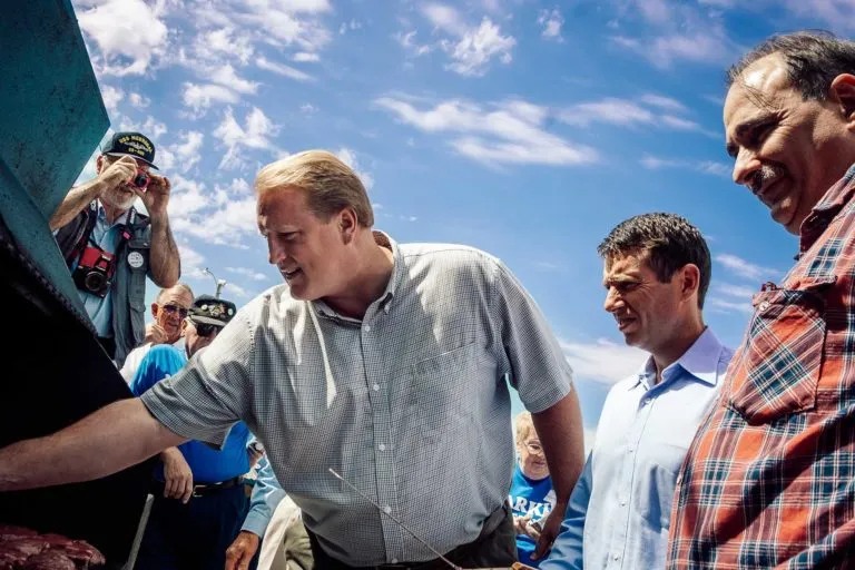 Iowa Governor Chet Culver works the grill at the 2010 Harkin Steak Fry as Obama advisors David Plouffe and David Axelrod look on