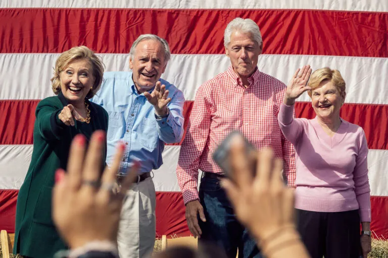 Hillary Clinton, Tom Harkin, Bill Clinton, and Ruth Harkin wave to a crowd from a stage