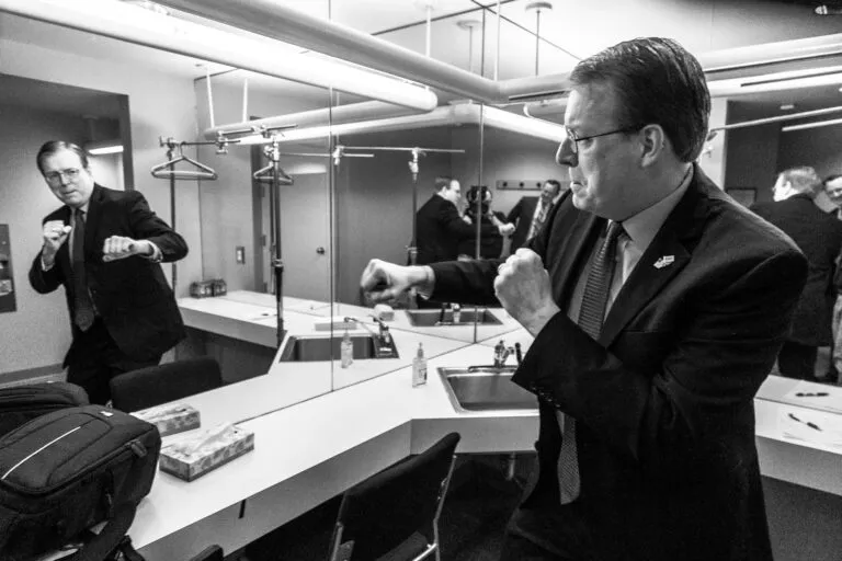 Iowa State Senator Rob Hogg shadowboxes in a mirror before a debate