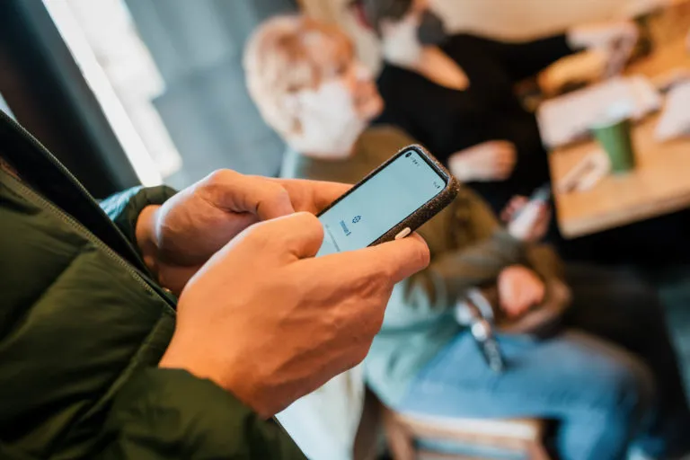 A person holding a smartphone as their canvassing app opens