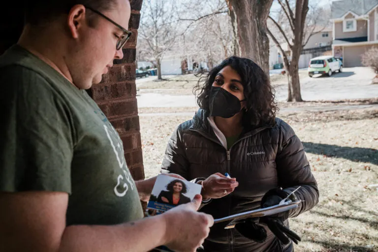 Megan Srinivas speaking with a man on his doorstep