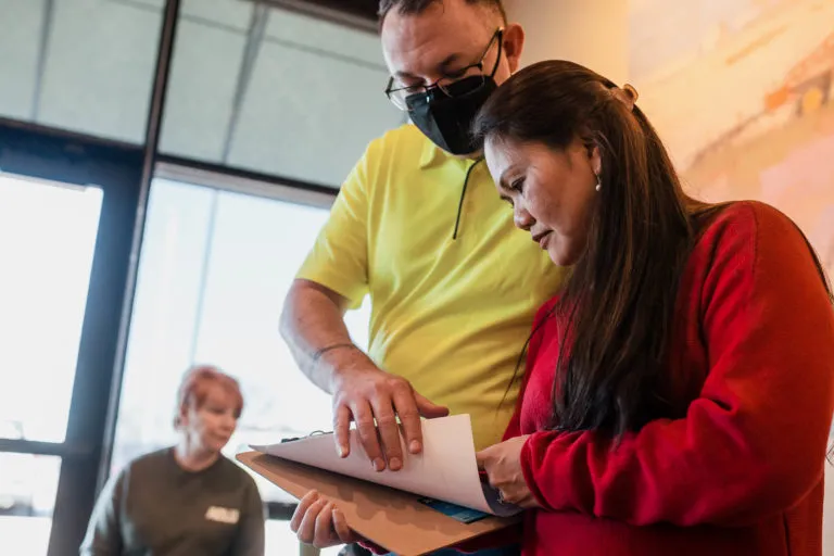 Two volunteers look over door knocking lists